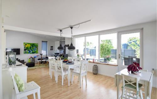 a kitchen and living room with a table and chairs at Lovely Home In Juelsminde With Kitchen in Sønderby