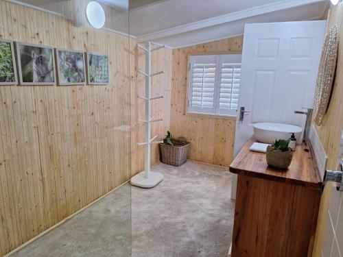 a bathroom with wooden walls and a sink and a shower at Mar Azul 4 in Ponta Malongane