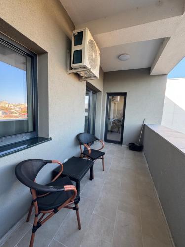 a waiting room with two chairs and a window at Apartament Central in Craiova