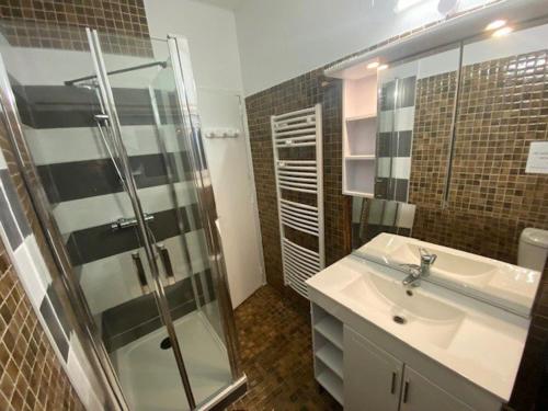 a bathroom with a sink and a glass shower at Charmant Appartement 3 Pièces à Arette - 2 Chambres, Casiers à Skis, Parkings Gratuits - FR-1-602-26 in Arette