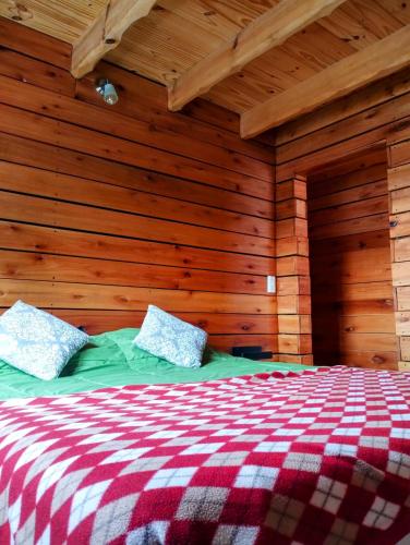 a bedroom with a bed in a wooden wall at Pizarra Escondida in El Chalten