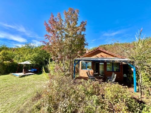 a small house with two chairs in a yard at Ugra Miradore Balatonalmadi in Balatonalmádi