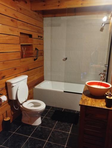 a bathroom with a toilet and a tub and a sink at Pizarra Escondida in El Chalten