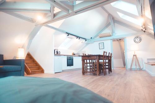 une chambre avec un lit, une table et des chaises dans l'établissement Le Nid dAigle - Spacieux logement sous les toits, à Tours