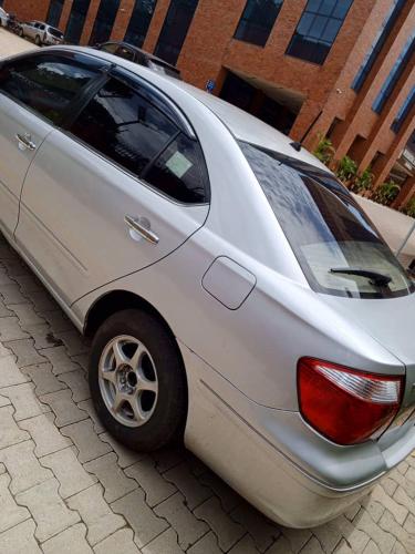 une voiture argentée garée dans une rue pavée dans l'établissement Wish UBD 554M, à Kampala