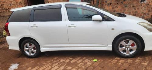 une voiture blanche garée dans une rue pavée dans l'établissement Wish UBD 554M, à Kampala