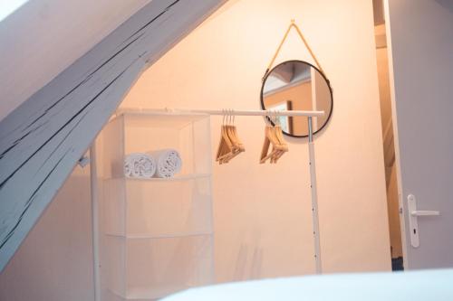 La salle de bains est pourvue d'un miroir et d'un porte-serviettes. dans l'établissement Le Nid dAigle - Spacieux logement sous les toits, à Tours