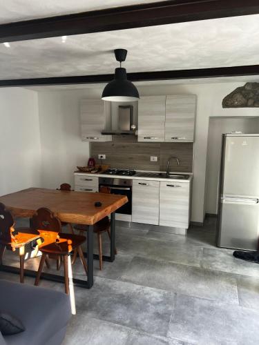 a kitchen with a wooden table and a refrigerator at Cascina Ürtigher in Gorno