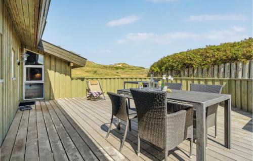 a patio with a table and chairs on a deck at Pet Friendly Home In Pandrup With Sauna in Blokhus