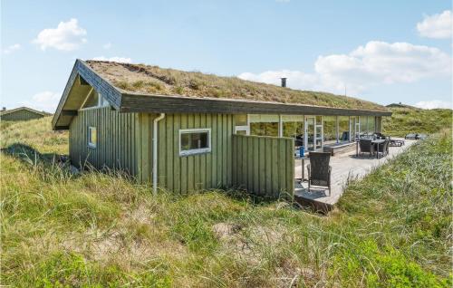 a green house with a grass roof on a beach at Pet Friendly Home In Pandrup With Sauna in Blokhus