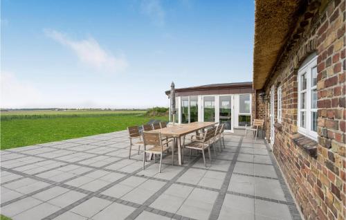 a patio with a table and chairs on a brick building at Lovely Home In Tim With Sauna in Halkær