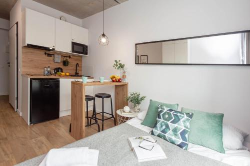 a living room with a couch and a kitchen at Apartamenty Silver Place in Szczecin