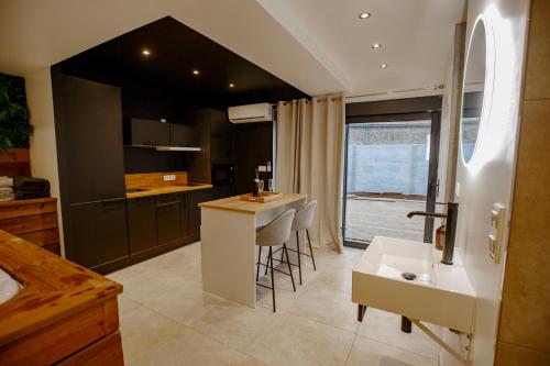 - une cuisine avec un bar, un évier et un comptoir dans l'établissement L'Hakuna - Suite & Spa, à Fontaine-Notre-Dame