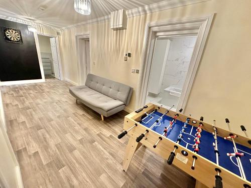 a living room with a ping pong table and a couch at Glen Fern Lodge - Garden Apartment with Parking - Heart of Bournemouth Town Centre - Close to Beach - Darts and Table Football - Sleeps 11 in Bournemouth