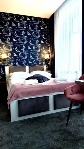 a bedroom with a large bed with a red blanket at Willa Akacja in Gdynia