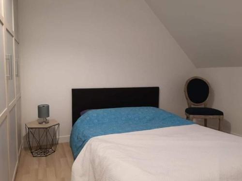 une chambre avec un lit avec une couverture bleue dans l'établissement Coeur de ville, 3 chambres, 6 personnes, à Paimpol