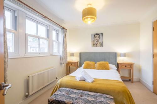 ein Schlafzimmer mit einem Bett in einem Zimmer mit Fenstern in der Unterkunft Fabulous Central 3Bed Apt - With Parking in Cambridge