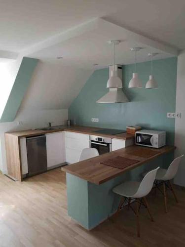 - une cuisine avec un comptoir et des chaises dans la chambre dans l'établissement Coeur de ville, 3 chambres, 6 personnes, à Paimpol