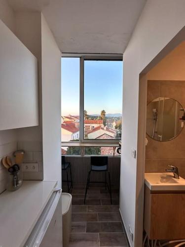 une salle de bain avec un lavabo et une grande fenêtre dans l'établissement La dune vue mer, à La Seyne-sur-Mer