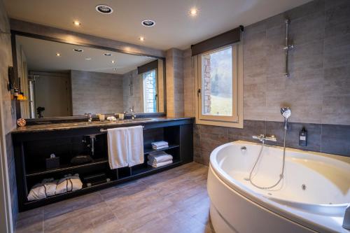 a bathroom with a tub and a large mirror at Serras Andorra in Soldeu