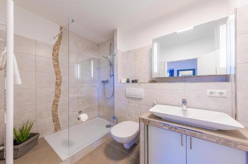 ヴァーレンにあるModernes Apartment "Stadtblick"- Aussicht auf Altstadt und Müritzの洗面台、トイレ、シャワー付きのバスルーム