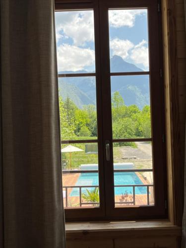 a window with a view of a swimming pool at BO LODGE in Le Bourg-dʼOisans