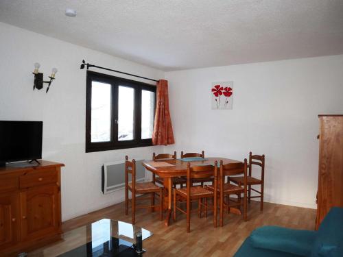 une salle à manger avec une table, des chaises et une télévision dans l'établissement Studio lumineux pour 4 personnes proche centre, Les Orres - FR-1-322-213, aux Orres