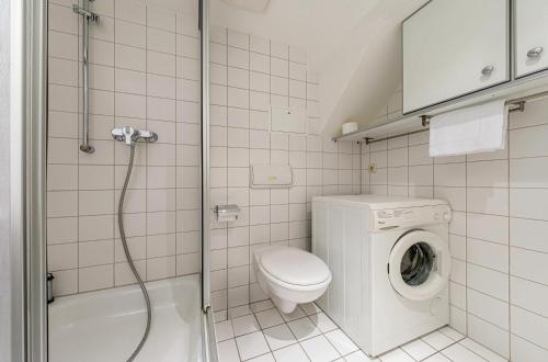 a bathroom with a toilet and a washing machine at Ferienwohnung Kietzspeicher - Maisonettewohnung im Herzen der Stadt in Waren