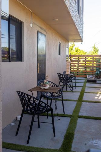 a patio with four chairs and a wooden table at Villa on the Rocks Fast Wi-Fi 5 mins to beach AC & 55 TV in all rooms in The Rock