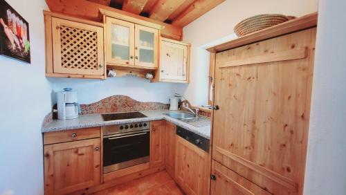 a kitchen with wooden cabinets and a stove top oven at Stodertraum 3 "Löwenzahn" by Alpenidyll Apartments in Weyern