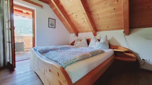a bed in a room with a wooden ceiling at Stodertraum 3 "Löwenzahn" by Alpenidyll Apartments in Weyern