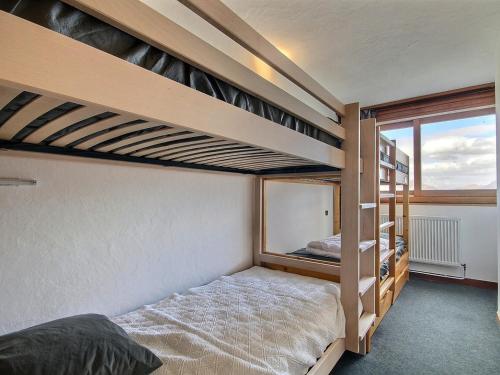 une chambre avec deux lits superposés et une fenêtre dans l'établissement Appartement 3 pièces au pied des pistes avec balcon, animaux admis - FR-1-455-86, à La Plagne