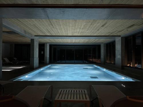 - une grande piscine avec banc dans un bâtiment dans l'établissement Duplex confort avec piscine et spa, pied des pistes - FR-1-461A-5, à Arc 1600