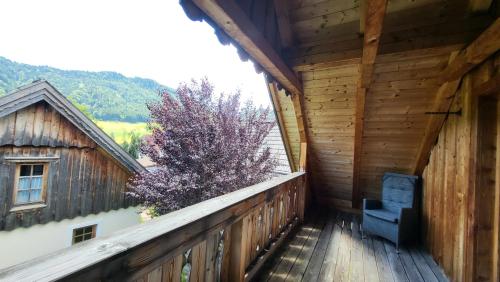 a balcony of a wooden house with a chair at Stodertraum 5 "Schlüsselblume" by Alpenidyll Apartments in Weyern