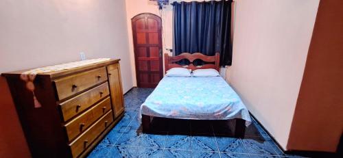イーリャ・グランデにあるapartamento frente da praiaのベッドとドレッサーのある小さな寝室