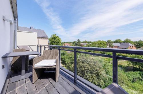 a balcony with a table and chairs on a deck at Boddensonne in der Alten Seefahrtschule in Wustrow