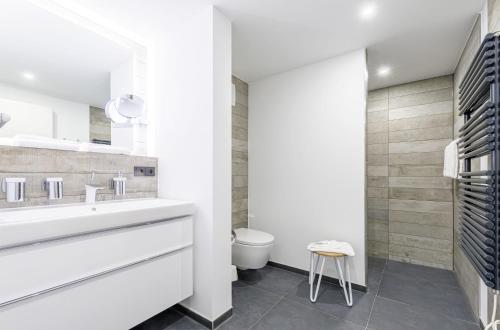 a white bathroom with a sink and a toilet at Boddensonne in der Alten Seefahrtschule in Wustrow