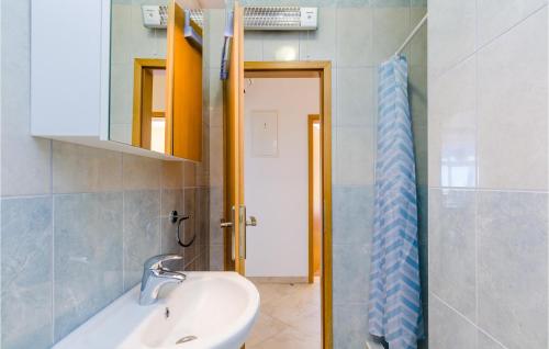 a bathroom with a sink and a mirror and a tub at Cozy Apartment In Dubravka With Sauna in Gruda