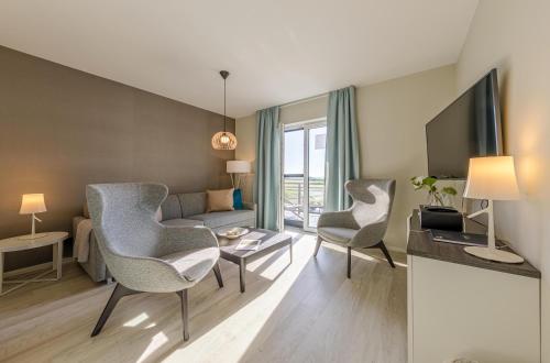 a living room with two chairs and a couch at 5 Sterne Apartment Boddenoase mit Ostseeblick in Wustrow