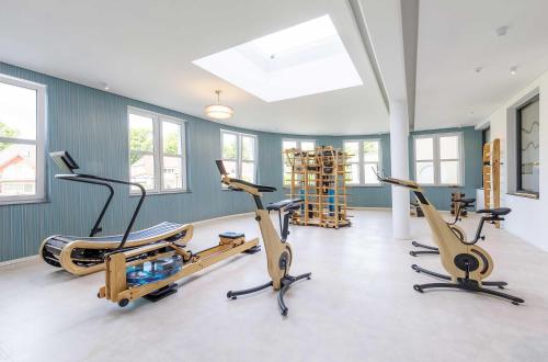 a gym with three exercise bikes in a room at 5 Sterne Apartment Boddenoase mit Ostseeblick in Wustrow