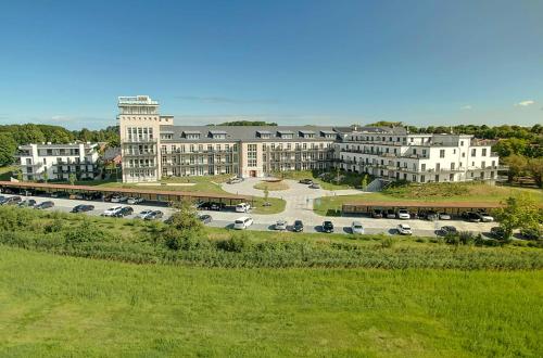 a large building with cars parked in a parking lot at James Cook Suite - 2 Schlafzimmer, 2 Bäder, Boddenblick & Sauna in Wustrow