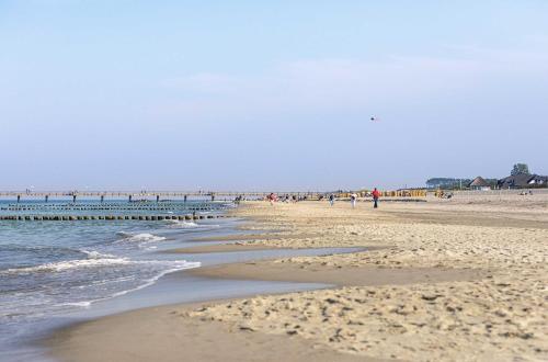 a group of people walking on the beach at Boddenflair in der Seefahrtschule in Wustrow