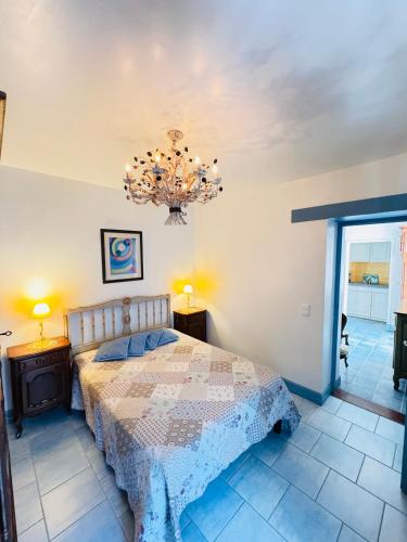 une chambre avec un lit et un lustre dans l'établissement Demeure François de l'Isle du Fief - Charme unique, à La Barre-de-Monts