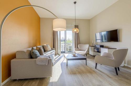 a living room with a couch and two chairs at 5 Sterne Apartment Humboldtsuite - Seefahrtschule Wustrow in Wustrow