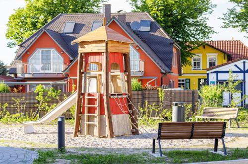 a playground with a slide in front of a house at 5 Sterne Apartment Humboldtsuite - Seefahrtschule Wustrow in Wustrow