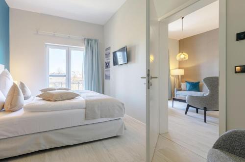 a bedroom with a bed and a living room at Columbus Suite mit Ostbalkon in Wustrow