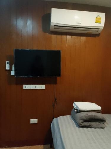 a room with a tv and a bed with a bed sidx sidx sidx at Lucky Guest house in Karon Beach