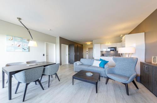 a living room with a couch and a table and chairs at Dünenquartier - 3 Obergeschoss mit Ostseeblick - 600m zum Strand in Wustrow