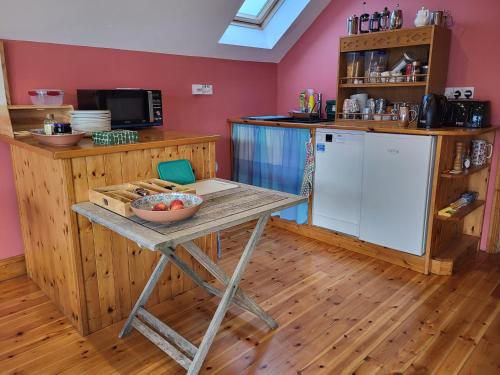 a kitchen with a table with a bowl of fruit on it at The Boat House in Adrigole