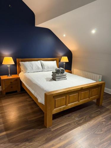 a bedroom with a large bed with a blue wall at Rooms at The Copper Tap in Omagh
